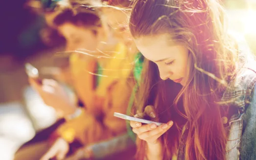 Mp21005943 happy teenage friends with smartphones outdoors